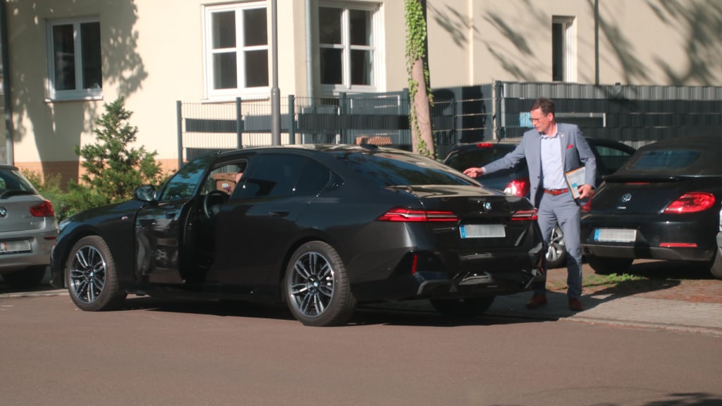 Halles Oberbürgermeister Alexander Vogt am Heck seines Dienstwagens. Sein kurz nach Amtsantritt verpflichteter ehemaliger Chauffeur war wohl unter dubiosen Umständen angestellt.