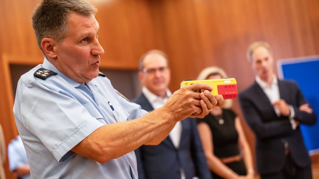 Ein Polizist erklärte die Funktionsweise eines Distanz-Elektroimpulsgeräts im vergangenen Jahr im Innnenministerium. (Archivfoto)