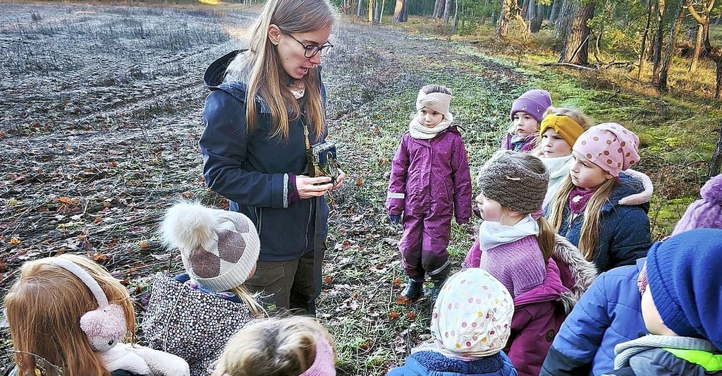 Julia Kamp vom Wolfskompetenzzentrum erklärt Kindern in Grieben eine Wildkamera. Gemeinsam ging es auf Spurensuche nach dem Wolf.