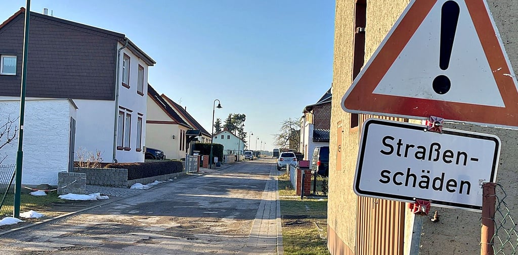 Ein Schild warnt seit Jahren vor Straßenschäden in Bittkau, viele Anwohner haben auch selbst Schilder gemalt, auf denen zum langsamen Fahren aufgefordert wird.
