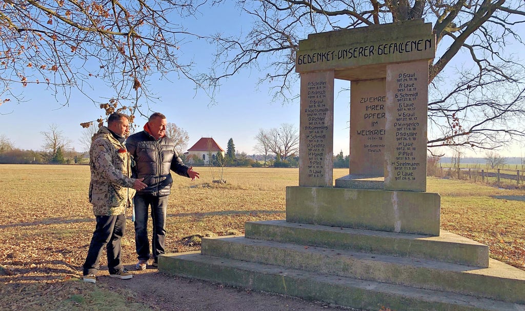 Christian  Wieloch (l.) und der Kleutscher Ortsbürgermeister Roland Gebhardt am  Denkmal für die Gefallenen beider Weltkriege.  