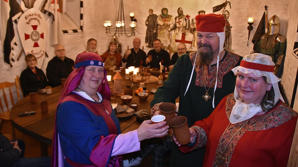 Gertrud von Haldensleben, dargestellt von Heike Seeger (vorn; v.l.), Jens Reinke als Lothar der III., Herzog von Sachsen, König und Kaiser sowie Anja Reinke als Richenza von Northeim, Herzogin in Sachsen, Königin und Kaiserin, stoßen im Stendaler Torturm mit Freunden auf die lebendige Stadtgeschichte an.