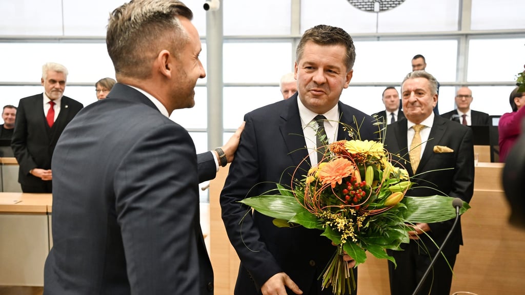 Sven Schulze bekommt Glückwünsche und einen Blumenstrauß vom AfD-Spitzenkandidaten Ulrich Siegmund.