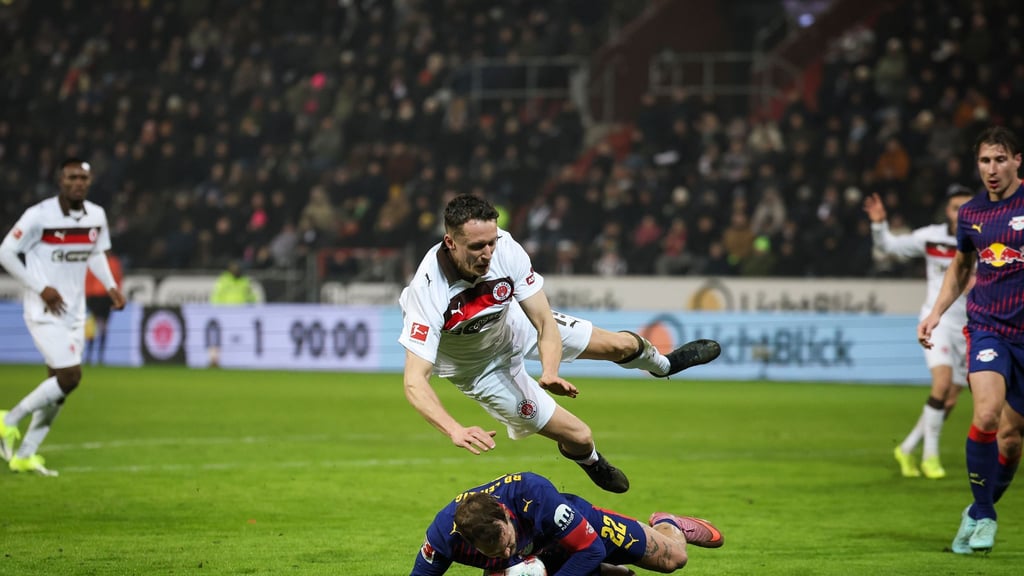 Strafstoß in der Nachspielzeit: Leipzigs David Raum (unten) foult St. Paulis Angreifer Martijn Kaars (oben)-