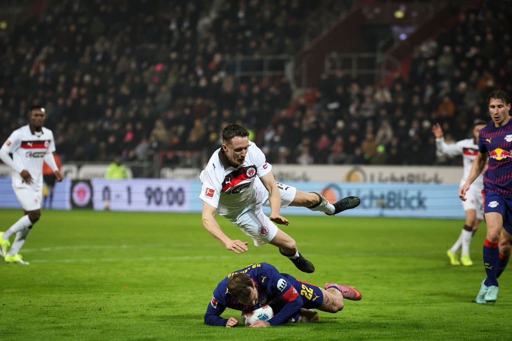 Strafstoß in der Nachspielzeit: Leipzigs David Raum (unten) foult St. Paulis Angreifer Martijn Kaars (oben)-