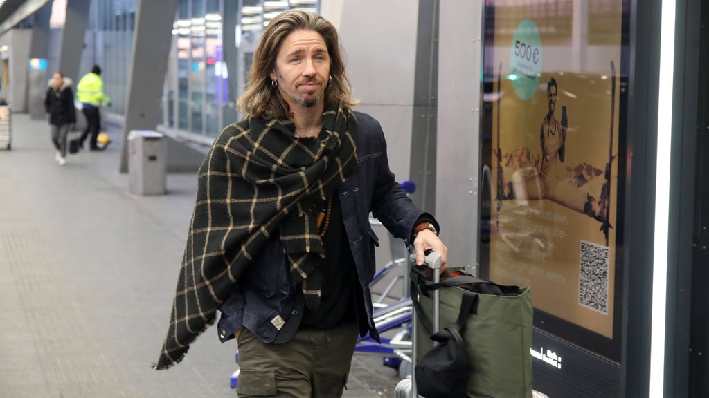 Gil Ofarim auf dem Weg zum Flugzeug, das ihn zu "Ich bin ein Star – holt mich hier raus" in den Dschungel bringt. Noch hat er ein zaghaftes Lächeln auf den Lippen.