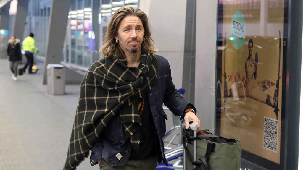 Gil Ofarim auf dem Weg zum Flugzeug, das ihn zu "Ich bin ein Star – holt mich hier raus" in den Dschungel bringt. Noch hat er ein zaghaftes Lächeln auf den Lippen.