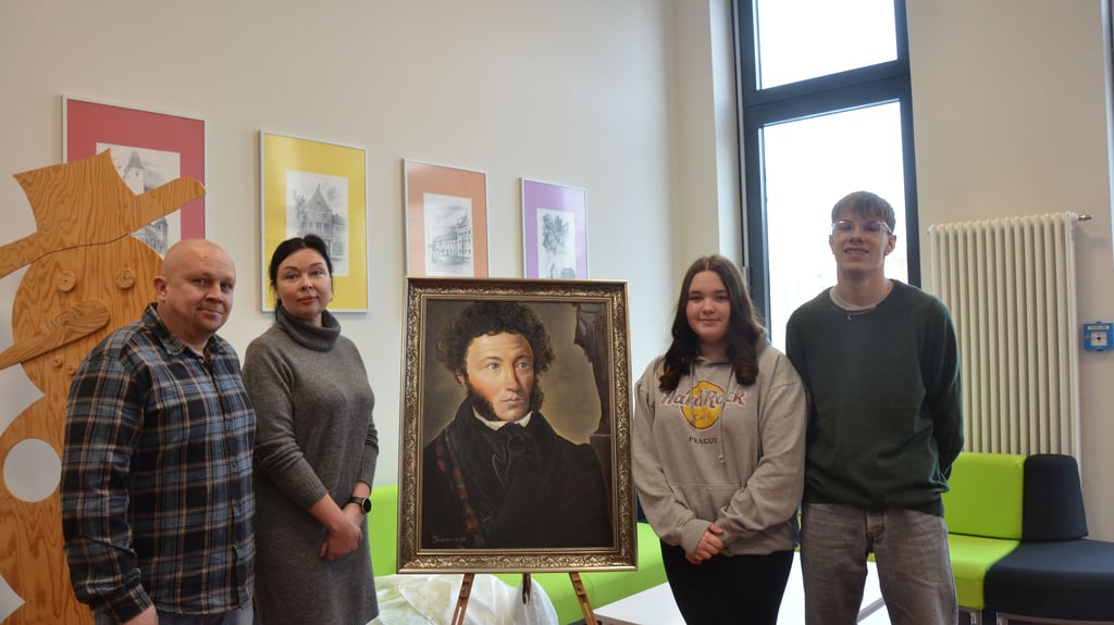 Künstler Juriy Starov (links) schenkt der Puschkinschule ein Porträt des Namensgebers. Bei der Übergabe mit dabei: Seine Frau Maria und die Zehntklässler Jasmin Stella Bentsch und Franz Wilhelm.