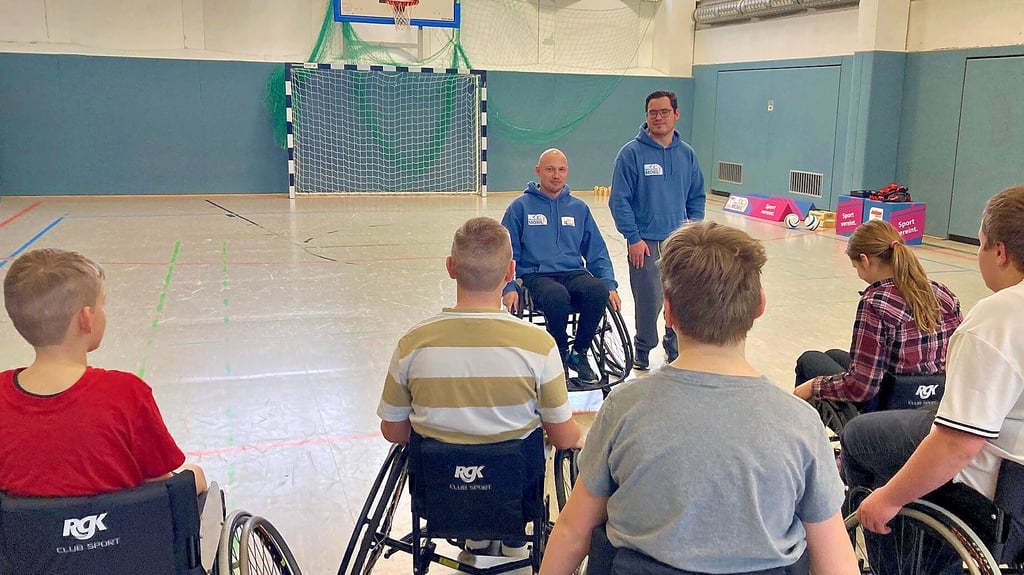 Pascal Scheffel (li.) und Moritz Jonas bringen den Kindern Rollstuhl-Basketball näher.
