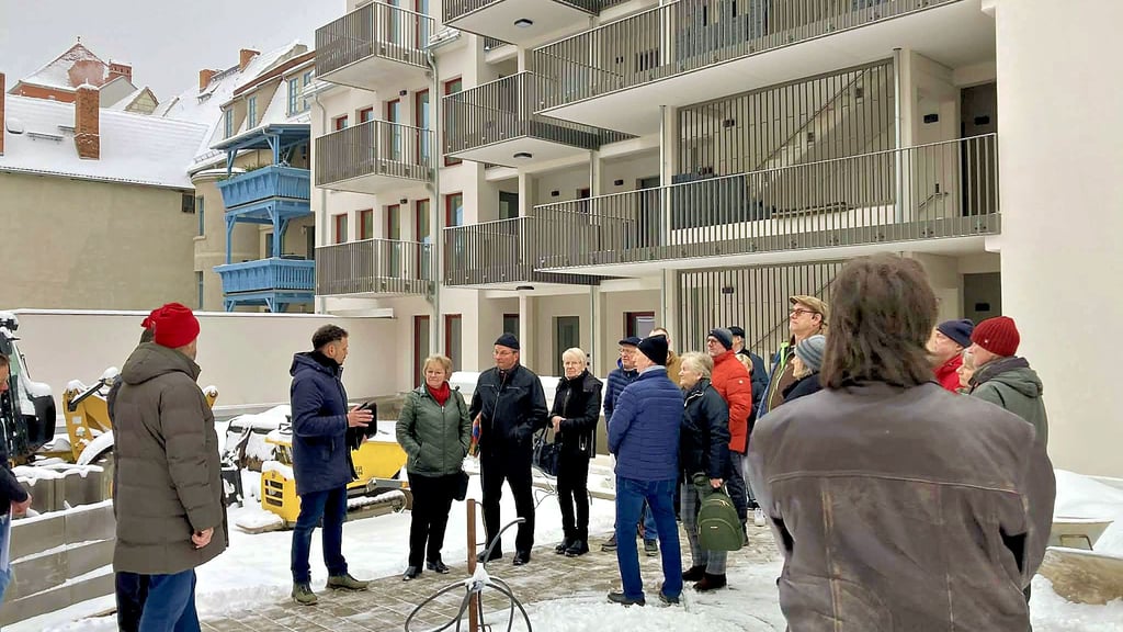 Die neuen Mieter der Hinterbreite 5 bis 7 in Aschersleben werden zur offiziellen Schlüsselübergabe auf dem verschneiten Innenhof begrüßt.  