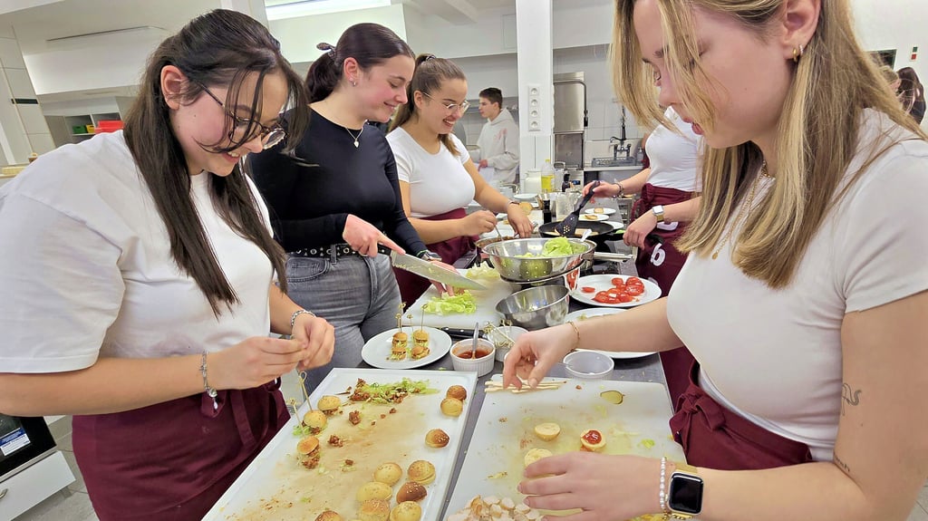 Die angehenden Erzieherinnen Caroline Künne (vorn links) und Jule Spangenberg (vorn rechts) helfen bei der Zubereitung von Speisen in der Lehrküche. Beide haben sich an der Wema zuvor zu Sozialassistenten ausbilden lassen.