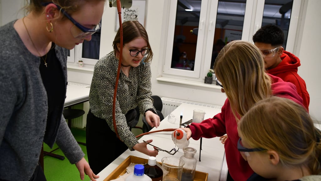 Im Chemiekabinett des Gymnasiums wurden Münzen „vergoldet“. Wie das  geht, erklärten die Elftklässler Laura Eilmes und Jonna Klein.