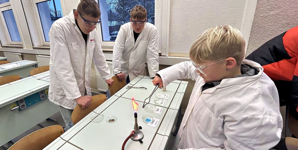 Unter Anleitung älterer Schüler führen künftige Fünftklässler erste chemische Versuche mit dem Bunsenbrenner durch.