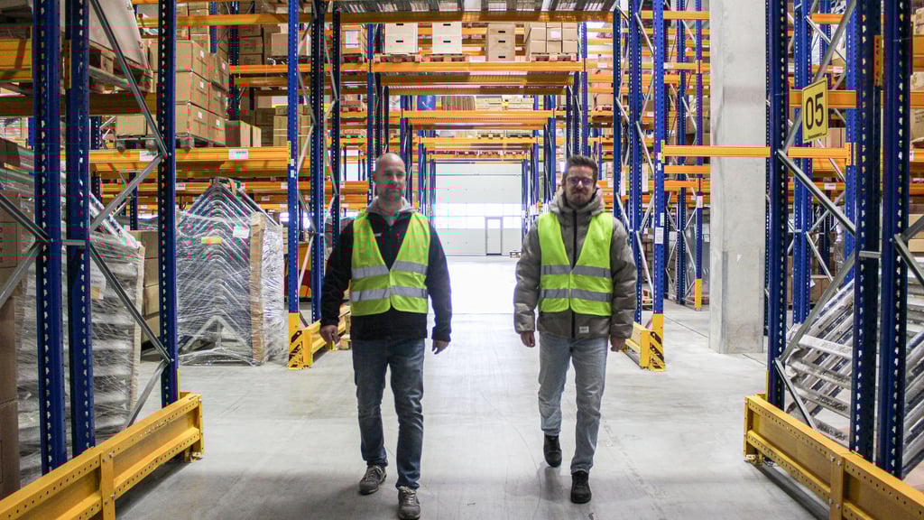 René Bomeier (l.) und Steven Schulze gehen durch die Hochregale einer der vielen Lagerhallen des Logistikzentrums von Sport-Thieme.