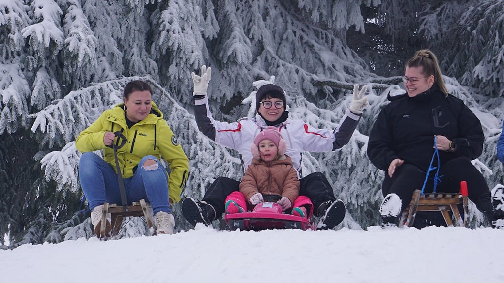 Anett Karcher (v.l.), Kriemhild mit Enkelin und Melanie Remus machen sich bereit zum Schlittenwettrennen. Rodeln ist in Lossa im Winter fast immer möglich – dank Schneekanone.