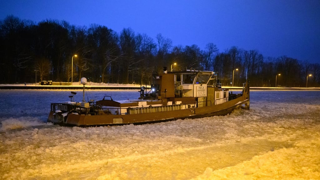 Ein Eisbrecher dreht am frühen Morgen auf dem vereisten Mittellandkanal vor der Schleuse Anderten Runden.