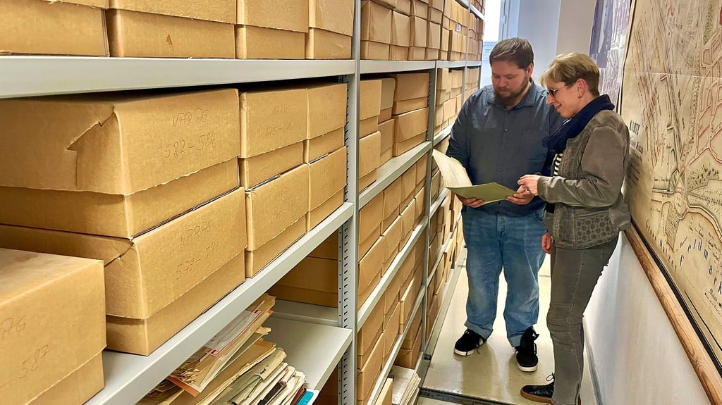 Matthias Hille und Britta Meldau sichten Akten in der unteren Etage des Archivs. Hier stehen die großen, schweren Rollregalanlagen. 