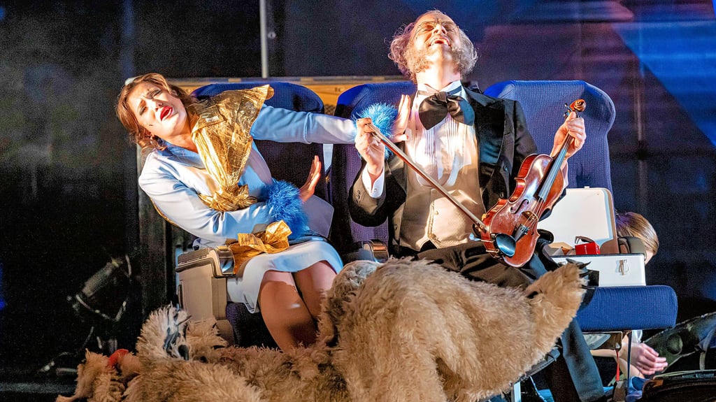 In Flugzeugsesseln: Eurydike (Vanessa Waldhart) und Orpheus  im Offenbach-Outfit (Robert Sellier) 