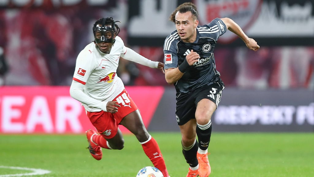 Yan Diomande (l.) versucht Frankfurts Arthur Theaté den Ball abzunehmen.