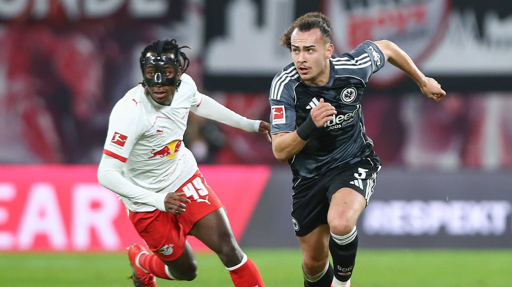 Yan Diomande (l.) versucht Frankfurts Arthur Theaté den Ball abzunehmen.