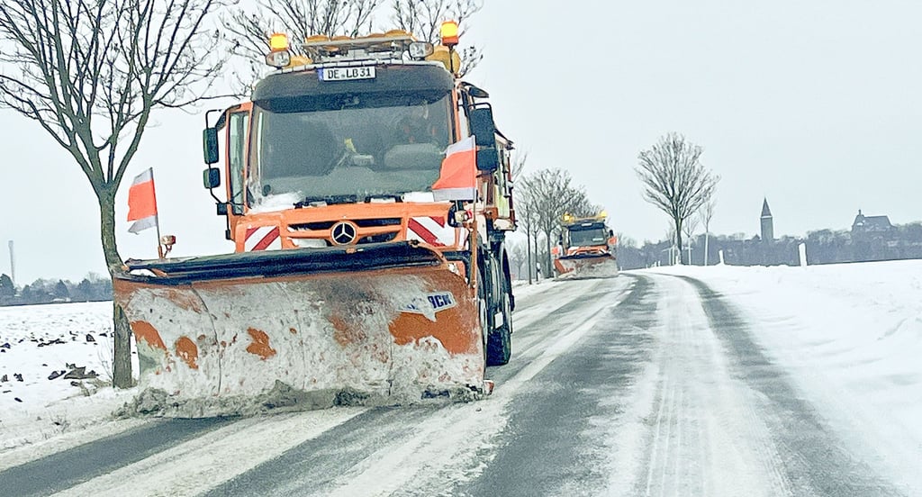 Schneepflüge räumen die L141 nahe Zörbig, nachdem Verwehungen die Fahrbahn eingeengt haben.