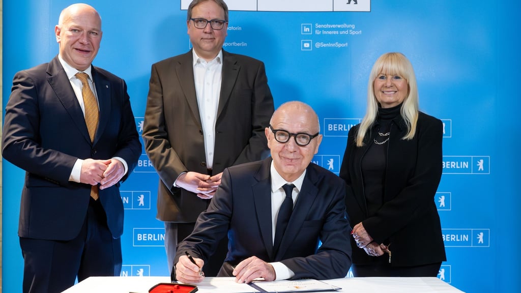 Bernd Neuendorf (vorne) bei der Unterzeichnung der Vereinbarung zum DFB-Pokal.