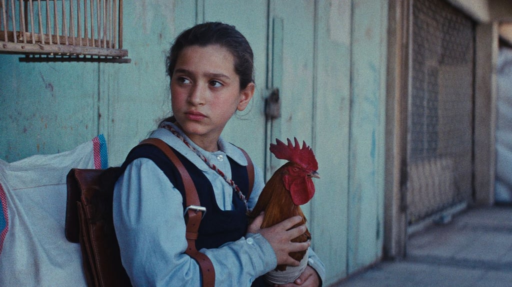 Lamia (Baneen Ahmed Nayyef) mit Hahn Hindi in einer Szene des Films „Ein Kuchen für den Präsidenten“ (undatierte Filmszene).