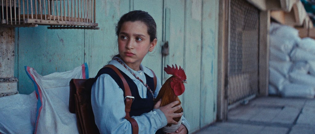 Lamia (Baneen Ahmed Nayyef) mit Hahn Hindi in einer Szene des Films „Ein Kuchen für den Präsidenten“ (undatierte Filmszene).