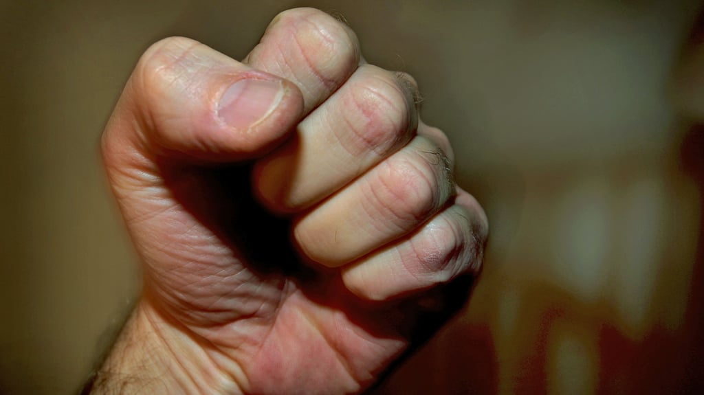 Ein Mann hat seine Hand zur Faust geballt.