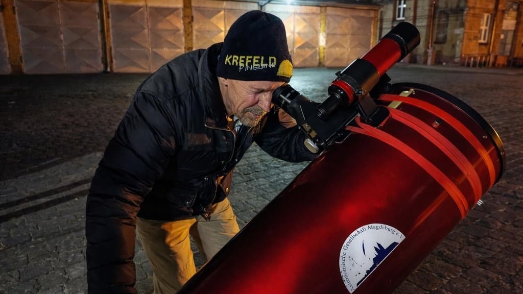 Ein Mitglied der Astronomischen Gesellschaft Magdeburg schaut durch ein Dobson-Teleskop.