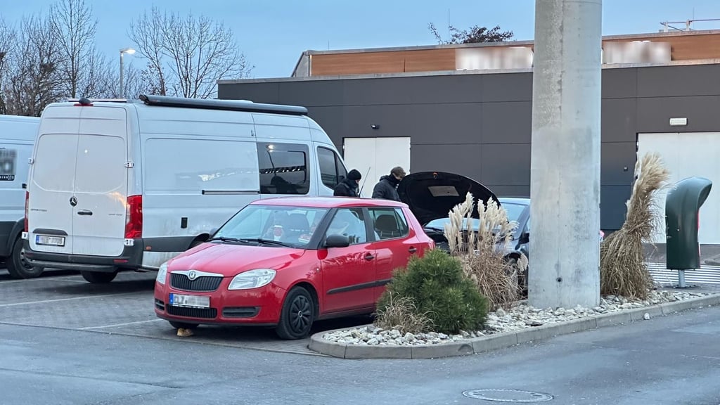 Auf dem Foto sind vermummte Polizeibeamte zu sehen, die auf dem Autohof nahe dem Mc-Donald’s-Restaurant ein Auto kontrollieren.