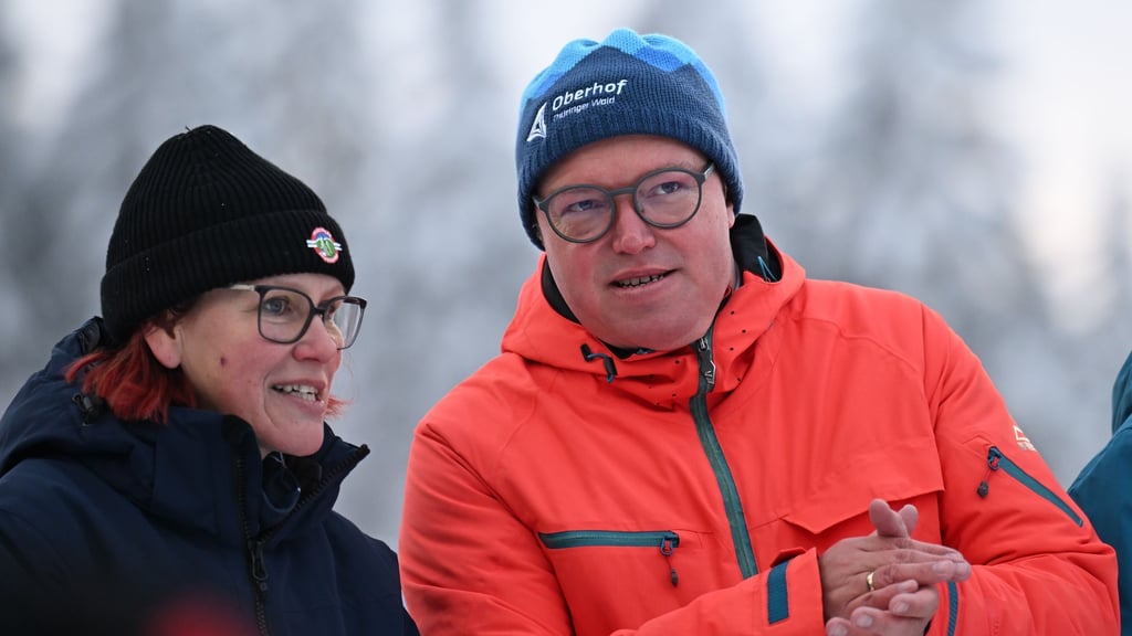 Will bei Olympia die Daumen drücken und für Thüringen werben: Ministerpräsident Mario Voigt (CDU) - hier mit der früheren Biathletin Kati Wilhelm beim Biathlon-Weltcup Anfang Januar in Oberhof (Archivfoto).