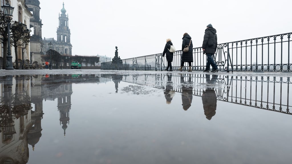 Passanten gehen auf der Brühlschen Terrasse vor der Katholischen Hofkirche in Dresden entlang. Ein regnerischer Start ins Wochenende erwartet die Menschen in Sachsen, Sachsen-Anhalt und Thüringen.
