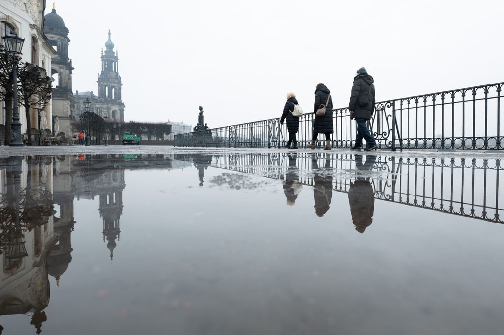Passanten gehen auf der Brühlschen Terrasse vor der Katholischen Hofkirche in Dresden entlang. Ein regnerischer Start ins Wochenende erwartet die Menschen in Sachsen, Sachsen-Anhalt und Thüringen.