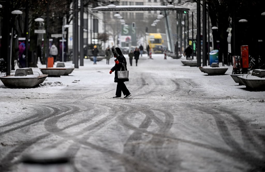 Passanten gehen durch Schneematsch am Potsdamer Platz.