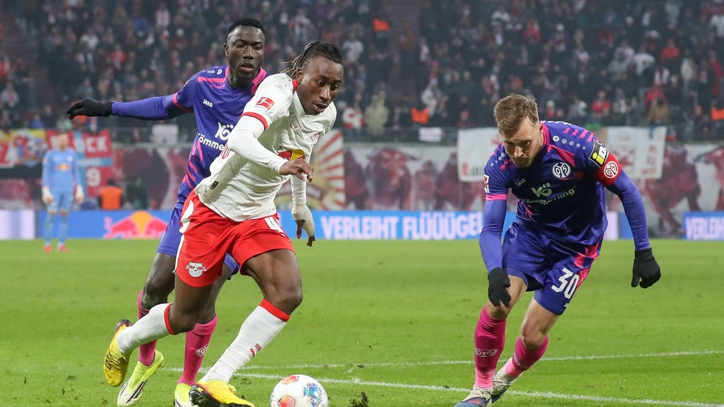 Yan Diomande (Mitte) verlädt zwei Gegenspieler im Spiel gegen Mainz 05.