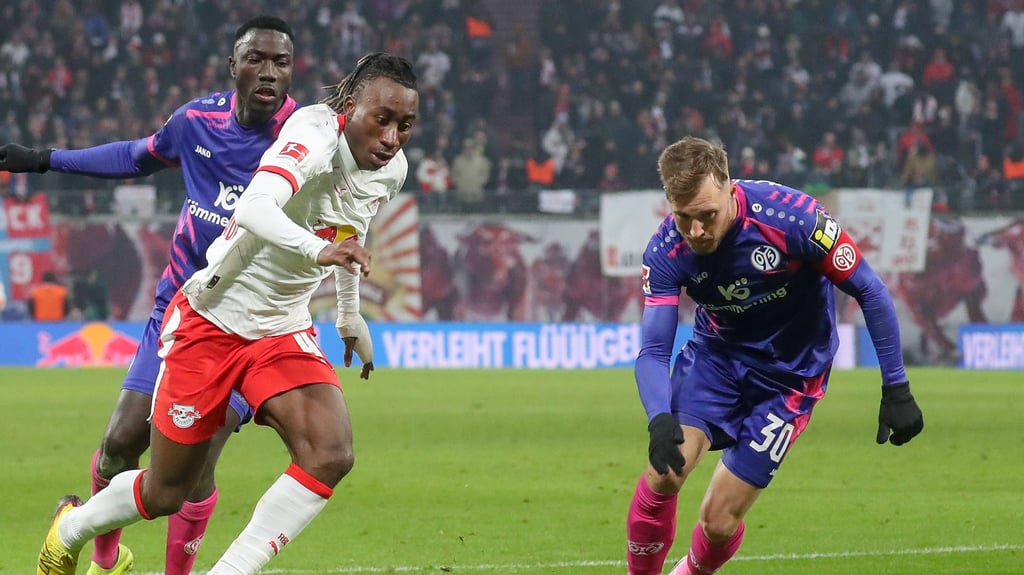 Yan Diomande (Mitte) verlädt zwei Gegenspieler im Spiel gegen Mainz 05.