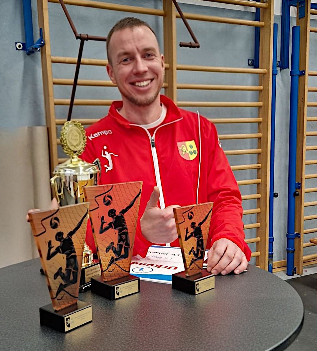Christian Adolf vom Organisationsteam der SG Calvörde präsentiert Trophäen des Volleyballturnierwochenendes, bei dem Nachwuchs- und Erwachsenenteams um die Plätze kämpften.