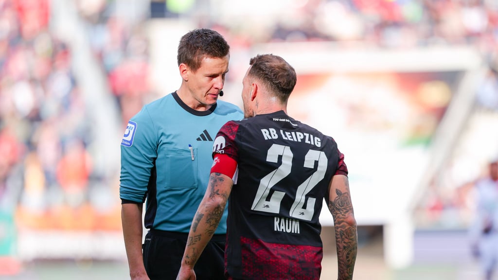 Schiedsrichter Daniel Siebert spricht mit RB-Kapitän Davi Raum.