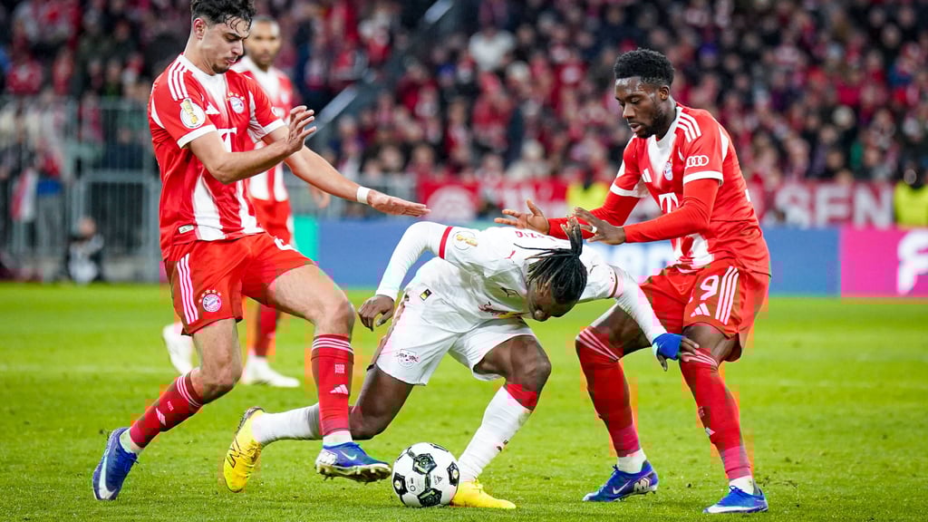 Yan Diomande kann sich nicht gegen Bayerns Alexandar Pavlovic (l.) und Alphonso Davies durchsetzen