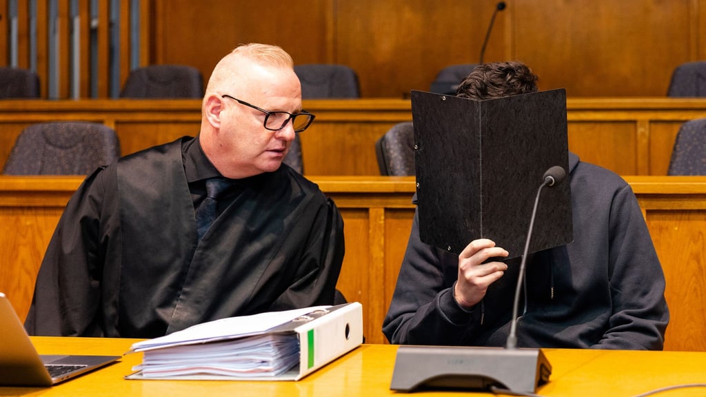 Der wegen Mordes angeklagte junge Mann sitzt neben seinem Verteidiger Michael Rehberger im Landgericht Saarbrücken.