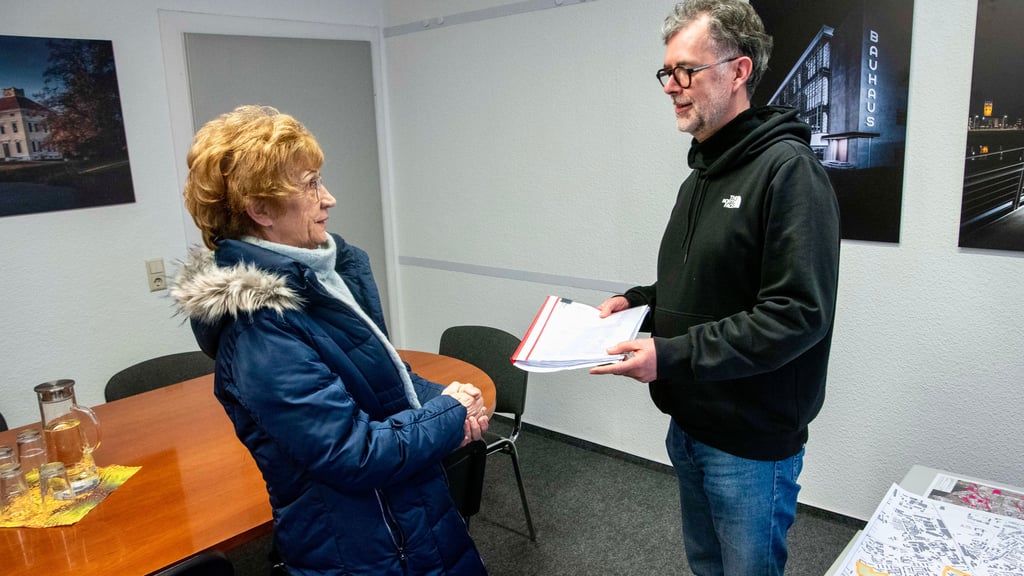 Rita Bahn-Kunz vom Stadtbezirksbeirat übergibt die gesammelten Unterschriften an Ingolf Schmidt von der Stadtverwaltung. 