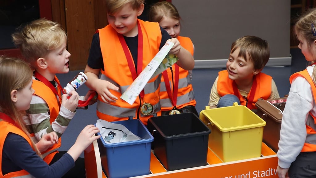 Wo Kassenbon und Joghurtflasche wohl hingehören? Die Kinder aus der Kita „August-Hermann Francke“ probieren es mit dem Spielzeug-Müllauto aus.
