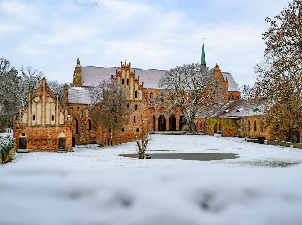 Die Landschaft am Kloster Chorin in Brandenburg ist mit Schnee bedeckt. Auf den Straßen ist ab Samstagabend wieder mit Glätte zu rechnen.