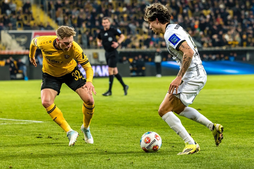 Dynamos Jonas Sterner (l) im Duell mit dem Elversberger Torschützen Nicholas Mickelson.