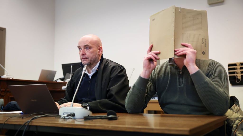 Der Angeklagte, der sein Gesicht verbirgt, soll Beihilfe zum Handel mit knapp 1,8 Tonnen Kokain geleistet haben.