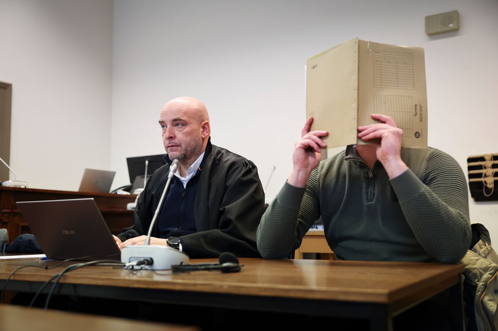 Der Angeklagte, der sein Gesicht verbirgt, soll Beihilfe zum Handel mit knapp 1,8 Tonnen Kokain geleistet haben.