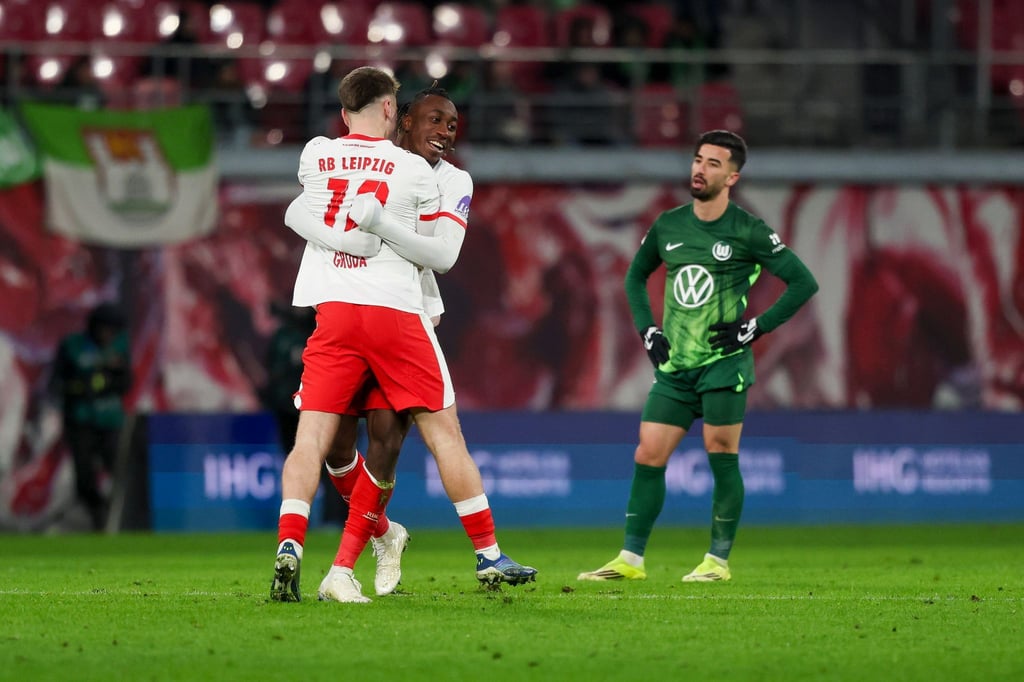 Wolfsburgs Stürmer Mohammed Amoura (r) sieht den Leipzigern beim Jubeln zu.