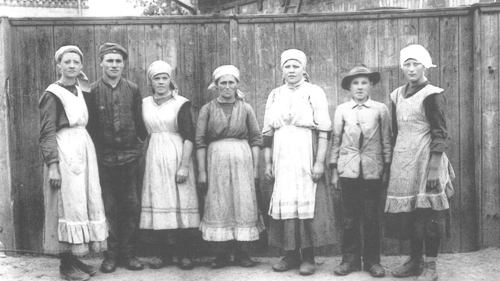 Zwangsarbeiterinnen und -arbeiter vor einem Bauernhof in Berga.