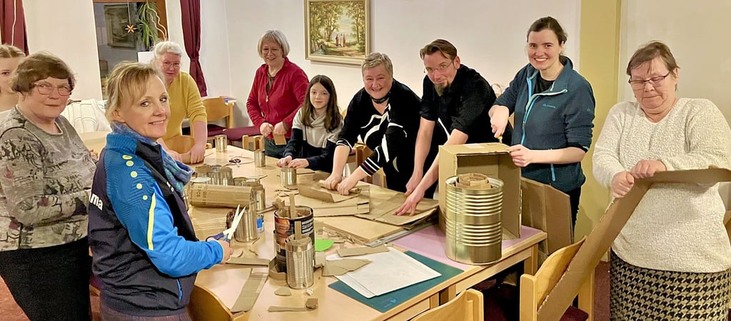 Mitglieder der evangelischen Gemeinde in Hohenmölsen stellen Dosenfackeln für bedürftige Menschen in der Ukraine her.